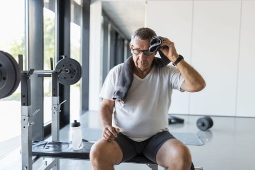 Active and healthy senior exercising in a gym