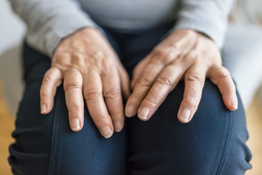 Senior woman at home suffering from arthritis