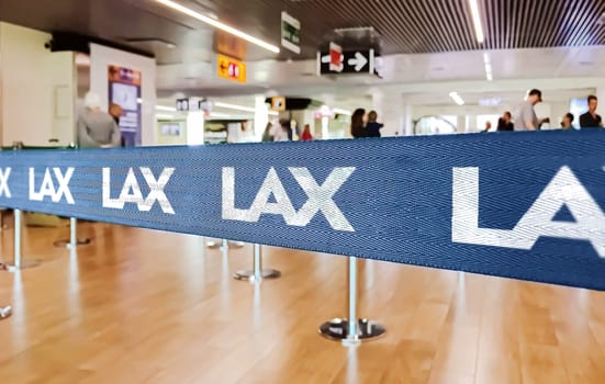 Los Angeles, USA, May 2022: Blue belt barrier with white Los Angeles International Airport logo. American Airlines is a major US-based airline. Travel and airport security