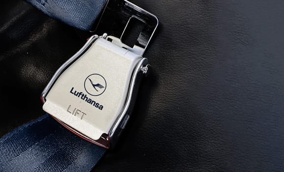 Berlin, German, May 2022: airplane passenger seat safety belt with the Lufthansa logo printed on the metal. Travel and airport security
