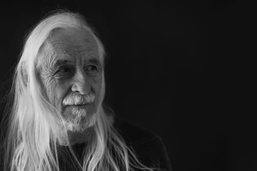 Low Key Studio Portrait of Long Gray Hair Old Man Closeup. Horizontally.