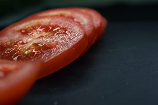 Close-up tomato slices on a black background. High quality photo