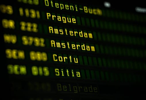 Flight information board at airport terminal closeup.