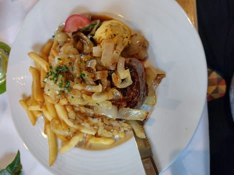 Delicious food: rump steak with fries,as well as herb butter and onions