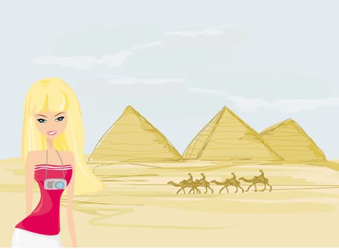 Travel gitl with camera on background the pyramids in Giza built for the pharaoh.