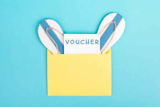 Blue colored summer and vacation background, voucher, flip flops in an envelope, copy space for text, holiday and tourism concept