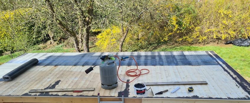 Roofing felt welding on bitumen roof roof repair with roofing felt and open flame propane tool on flat roof, leak with free space for text