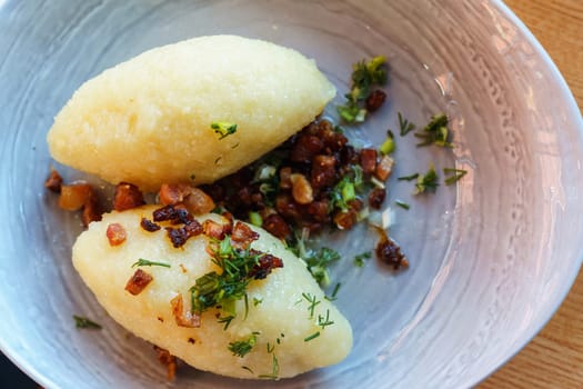 Lithuanian national dish zeppelins with fried bacon and herbs, top view