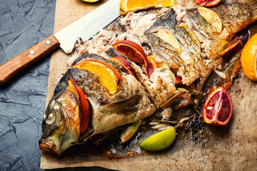 Delicious fish carp baked whole with lemon and oranges.