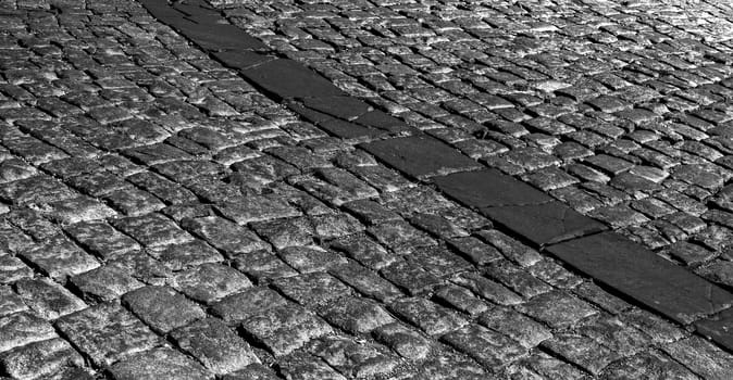 The road is made of black stone with reflected light.