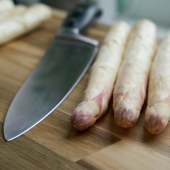 Fresh white asparagus directly from the field on a kitchen table