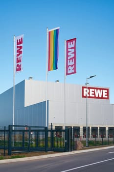 Waving flags in front of the new central warehouse of the German food retailer Rewe in the industrial area of Rothensee in Magdeburg