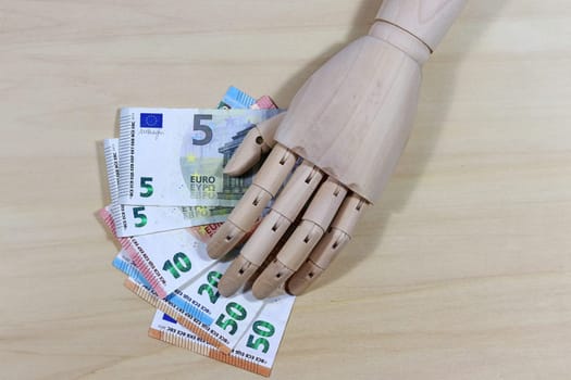 Life becomes more expensive. A wooden hand and banknotes
