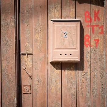 A mail box on wooden aged door orange