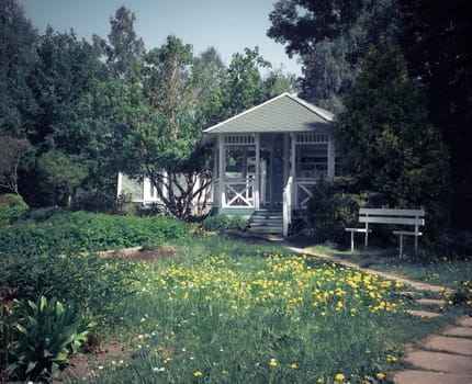 A vintage soviet traditional wooden gazebro in park landscape