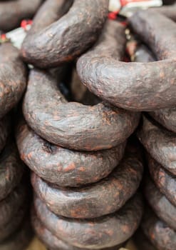 Black sausage or black iberian morcilla pile displayed at street market stall. Closeup