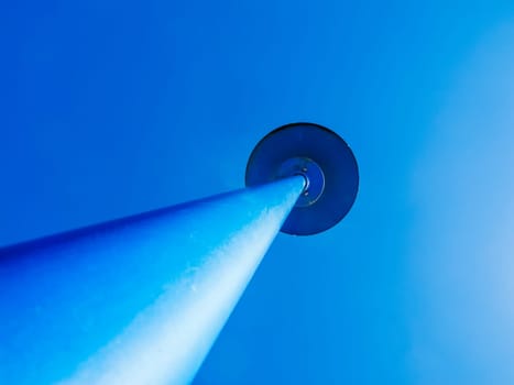 Perspective view of a blue lantern against a cloudless blue sky.