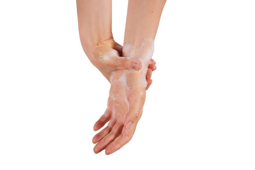 Unrecognizable woman rubbing foam into wrist while washing hands with soap against white background