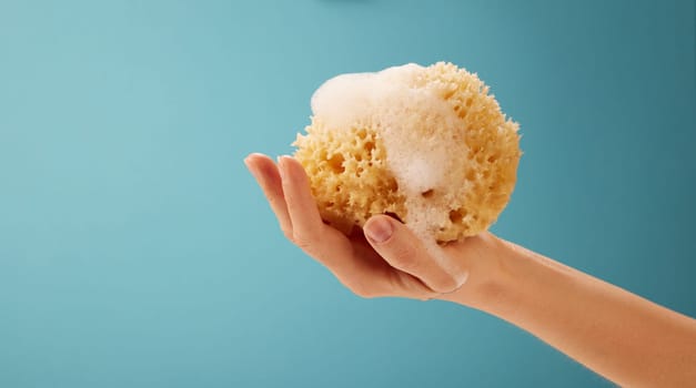 Hand of anonymous person showing a bath symbol of a sponge for wellness concepts