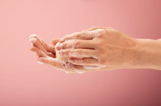 Soaping up hands with a foamy piece of soap.