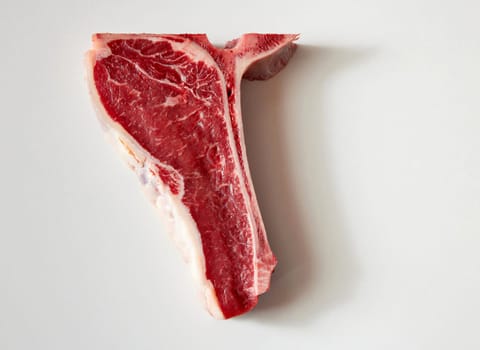 Top down view of a half t-bone steak for diet, eat less meat, safe the planet and no meat concepts.