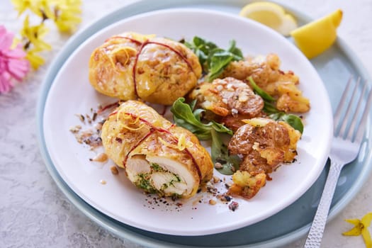 From above of delectable stuffed chicken thighs served with green herbs on plate for lunch at home