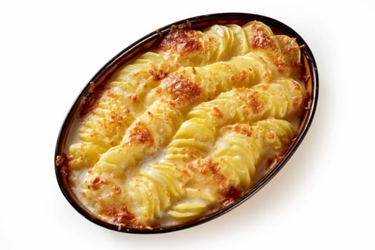 Tasty casserole dish with sliced potato and cheese in ceramic pan placed on white background
