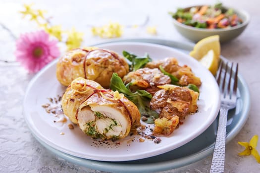 From above of appetizing stuffed chicken thighs served on plate with green herbs for lunch