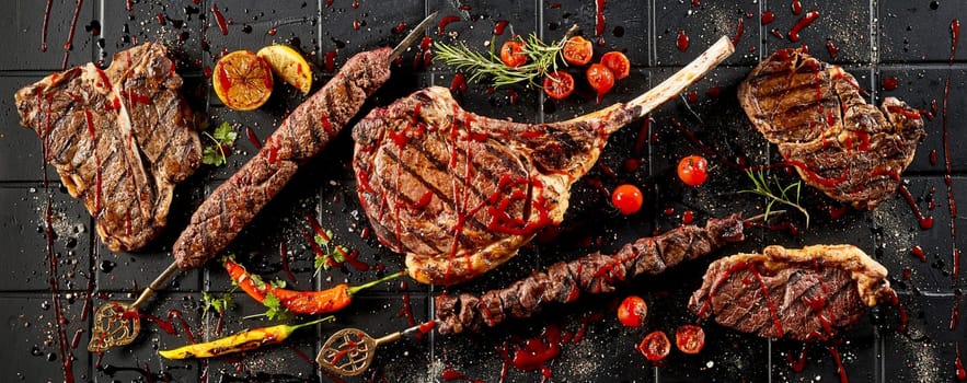 From above of appetizing grilled different meat steaks covered with spicy tomato sauce placed on black table
