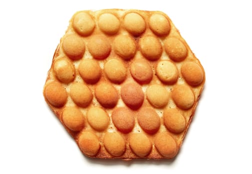 Top view of appetizing hexagon shaped egg wafer dessert placed on white isolated background in studio