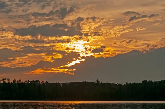 Sunlight Trying to Escape the Clouds at Sunset on Saganaga Lake in Quetico Provincial Park in Ontario