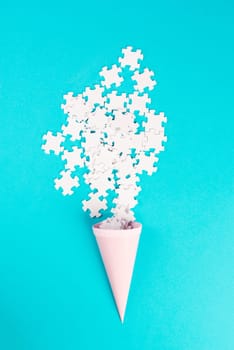 Cone with white puzzle pieces, blue background, spreading the jigsaw parts, searching for ideas and solutions, brainstorming as a team, flat lay