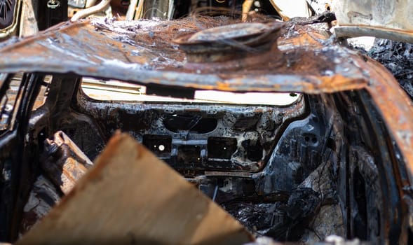 Broken and burned cars in the parking lot, accident or deliberate vandalism. Burnt car. Consequences of a car accident. Damaged by arson. Dump of civilian vehicles shot by Russian troops in Ukraine