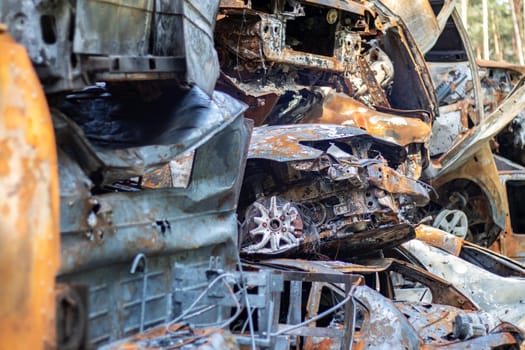A lot of rusty burnt cars in Irpen, after being shot by the Russian military. Russia's war against Ukraine. Cemetery of destroyed cars of civilians who tried to evacuate from the war zone