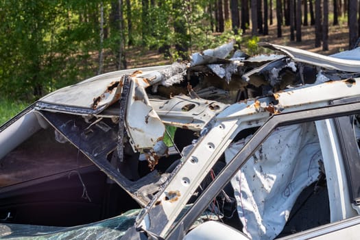 The remains of a civilian car, which was shot and destroyed by shell fragments. The actions of the Russian army during the evacuation of women and children during the Russian invasion of Ukraine