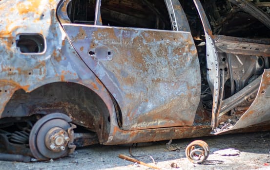 Broken and burned cars in the parking lot, accident or deliberate vandalism. Burnt car. Consequences of a car accident. Damaged by arson. Dump of civilian vehicles shot by Russian troops in Ukraine
