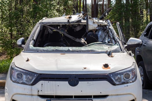 A car of civilians shot by the invaders during the war in Ukraine. Road accident or incident. Shrapnel holes in the body of the car. Atrocities of the Russian army. Ukraine, Irpen - May 12, 2022