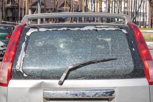 Traces of shots on the body of the car. War between Russia and Ukraine. Part of a civilian car that was fired upon during the evacuation of unarmed people from the combat zone