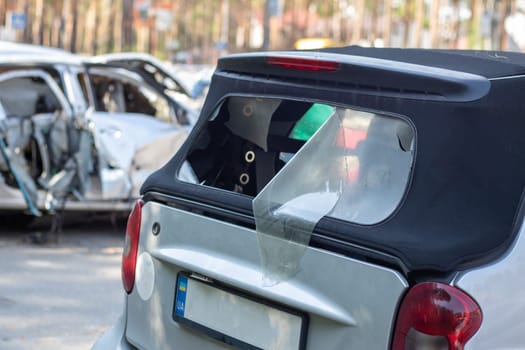 Many broken cars after a traffic accident in the parking lot of a restoration service station on the street. Car body damage workshop outdoors. Sale of insurance emergency vehicles at auction