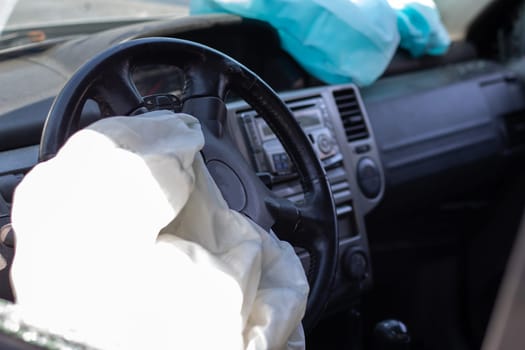 The driver's airbag deployed on the steering wheel of the car after the collision. Deflated airbags after flared deployment. The airbag deployed. Car after an accident. Safety device in the car