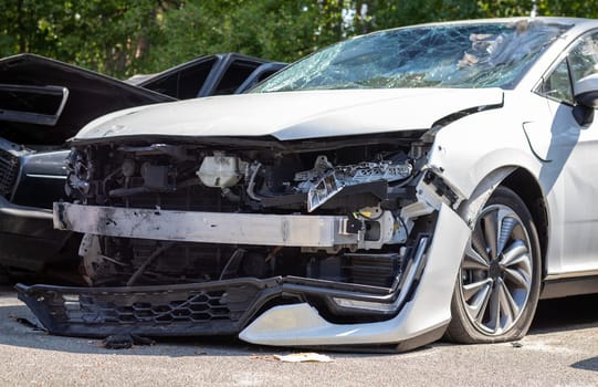 Many broken cars after a traffic accident in the parking lot of a restoration service station on the street. Car body damage workshop outdoors. Sale of insurance emergency vehicles at auction