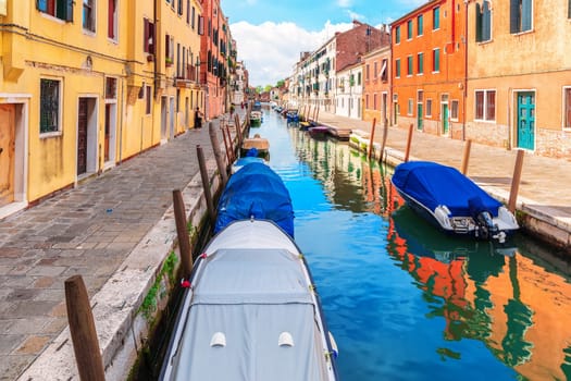Boats moored near an italian street in the Grand Canal of Venice.
