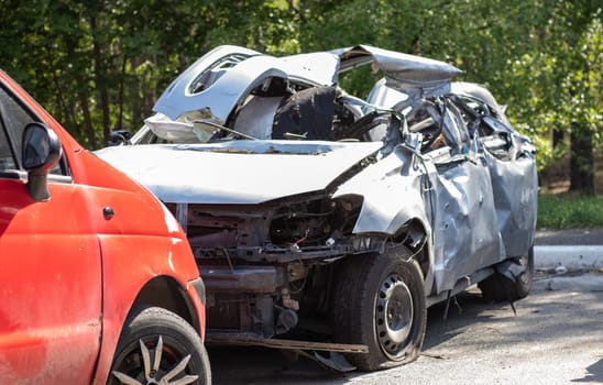 Many broken cars after a traffic accident in the parking lot of a restoration service station on the street. Car body damage workshop outdoors. Sale of insurance emergency vehicles at auction