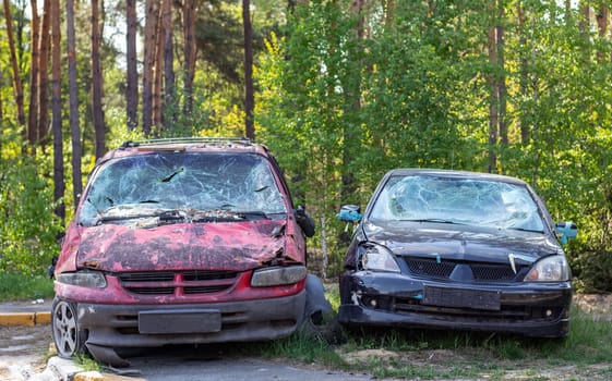 Many broken cars after a traffic accident in the parking lot of a restoration service station on the street. Car body damage workshop outdoors. Sale of insurance emergency vehicles at auction