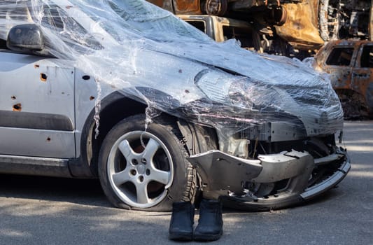 Shot, damaged cars during the war in Ukraine. The vehicle of civilians affected by the hands of the Russian military. Shrapnel and bullet holes in the body of the car. War of Russia against Ukraine