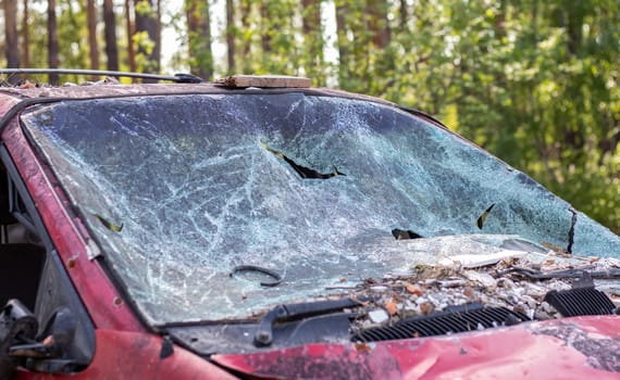Close-up of a car with a broken windshield after a fatal crash. Consequence of a fatal car accident. Automobile danger. Reckless dangerous driving. Vehicle after an accident with a pedestrian