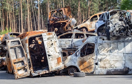 A lot of rusty burnt cars in Irpen, after being shot by the Russian military. Russia's war against Ukraine. Cemetery of destroyed cars of civilians who tried to evacuate from the war zone