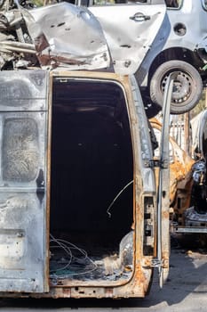 A lot of rusty burnt cars in Irpen, after being shot by the Russian military. Russia's war against Ukraine. Cemetery of destroyed cars of civilians who tried to evacuate from the war zone