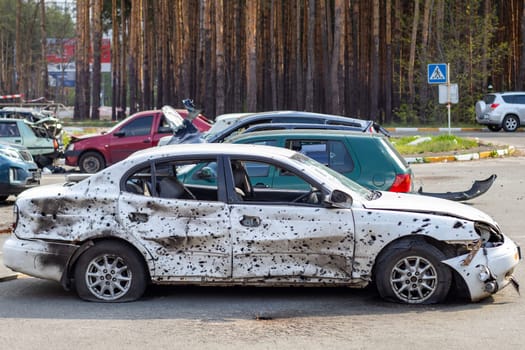 A car destroyed by shrapnel from a rocket that exploded nearby. Irpensky automobile cemetery. Consequences of the invasion of the Russian army in Ukraine. Destroyed civilian vehicle