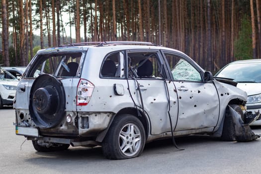 Shot, damaged cars during the war in Ukraine. The vehicle of civilians affected by the hands of the Russian military. Shrapnel and bullet holes in the body of the car. War of Russia against Ukraine
